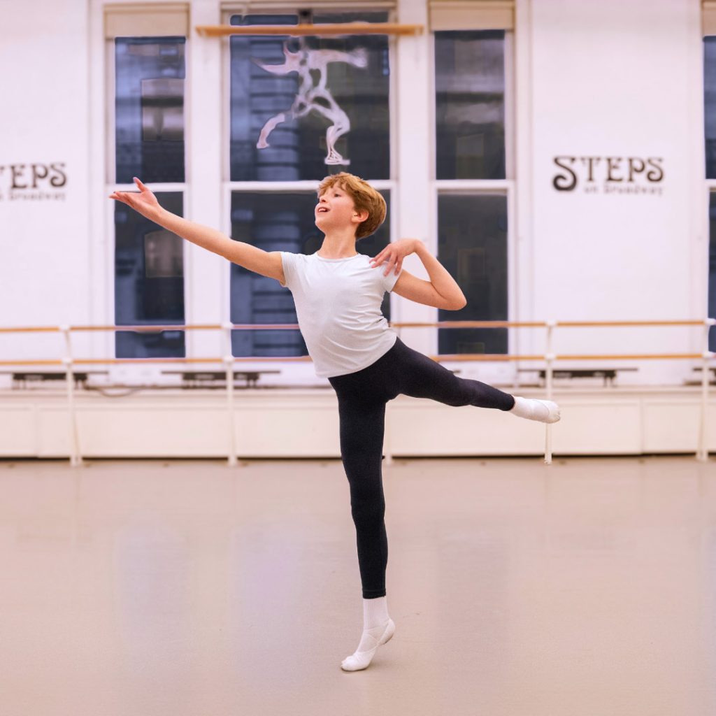 a young male pre professional ballet dancer in the center of the studio