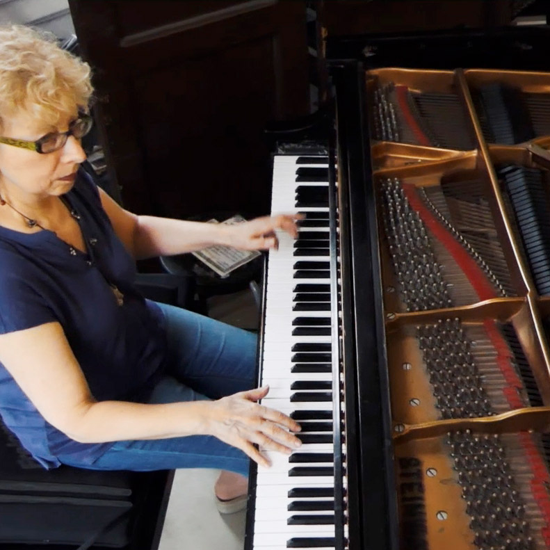 Olga Bazilevskaya photographed from above in casual attire playing piano